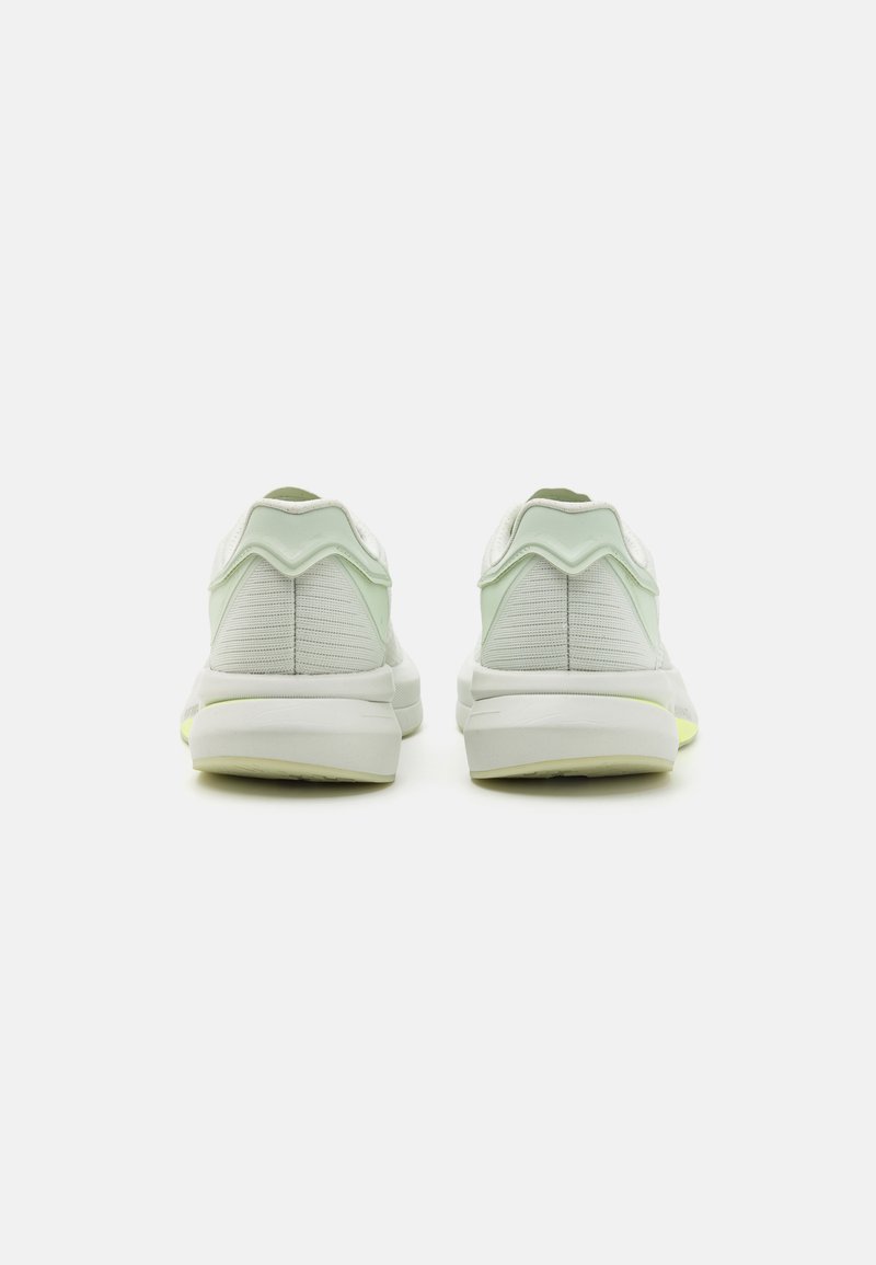 Rückansicht von athletischen Schuhen mit einem hellmintgrünen Obermaterial, strukturierten Elementen und einer Sohle mit gelben Akzenten und gepolstertem Design.