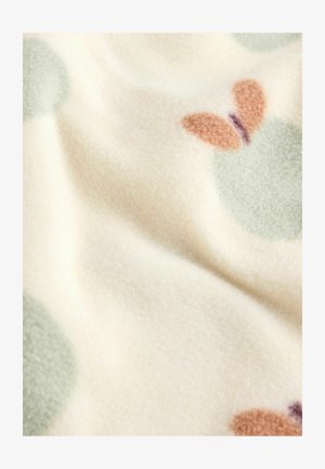 Manta de forro polar en color crema con grandes círculos verde menta y patrones de mariposas en marrón y púrpura. Textura suave y apariencia cálida.