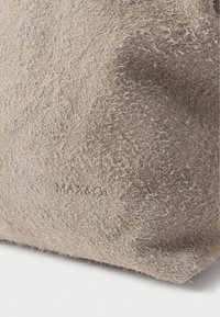 Beżowa torba o teksturowanej, miękkiej, włóknistej powierzchni. Zdobiona wytłoczonym napisem "MAX&Co." dla dodatkowego efektu. Kompaktowy i minimalistyczny design.