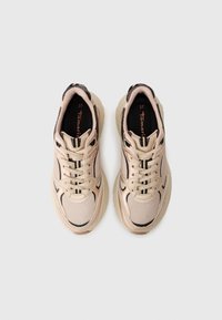 Beige Sport Schuhe mit Obermaterial aus Mesh und Synthetik, runder Zehenform, Schnürverschluss, kontrastierenden schwarzen Akzenten und Texturmittelsohle.