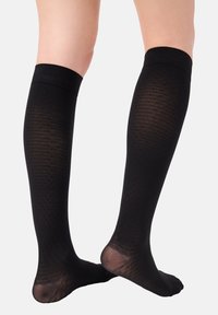 Schwarze knielange Socken mit strukturiertem Muster, ausgestattet mit einem glatten oberen Bündchen und verstärktem Fersenbereich. Leicht durchscheinendes Aussehen.
