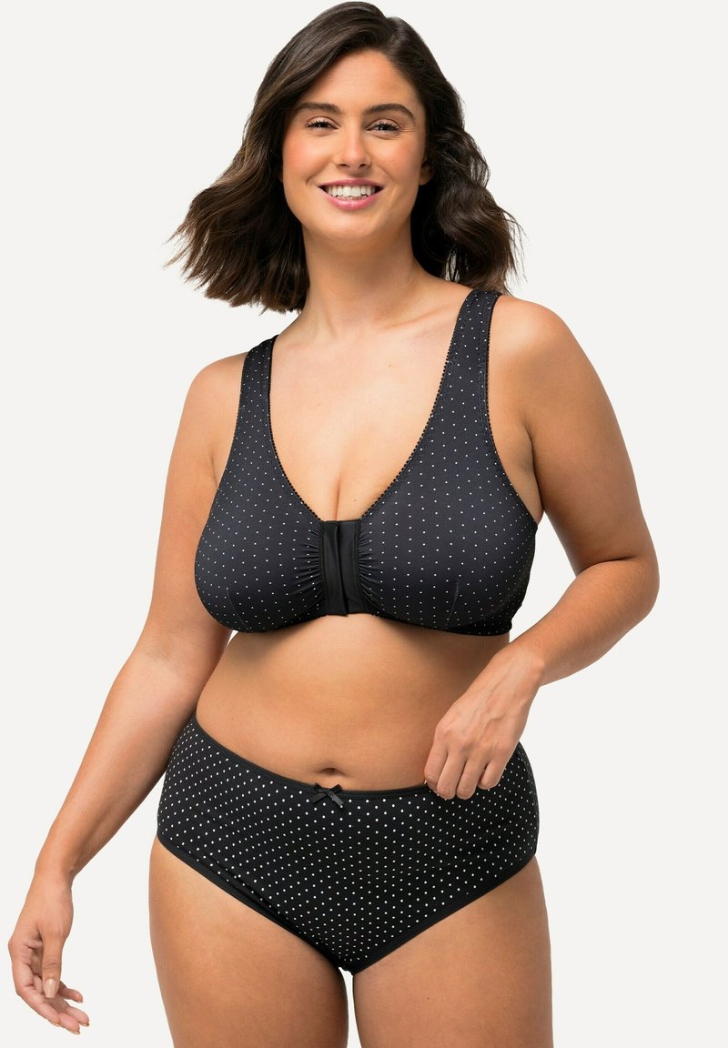 Zwart met stippen bikini set met een diep uitgesneden top, brede bandjes en een strikaccent in het midden; hooggesneden onderkant met bijpassend patroon.