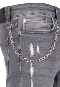 Grå denimjeans med slitte detaljer og en sølvkjedeaccessory festet til midjebåndet. Metallhardware synlig på lomma.