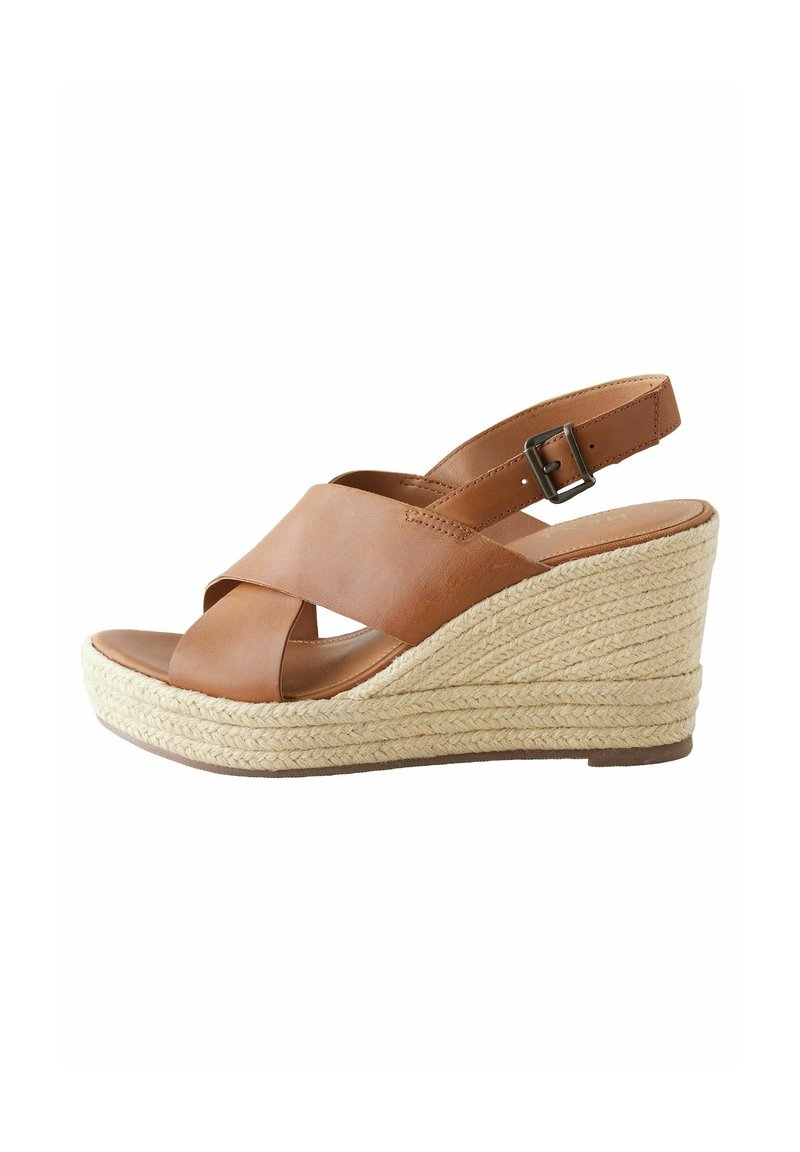 Bruine leren sleehak sandaal met kruislings straps, verstelbare enkelband en geweven jute details op de sleehak.