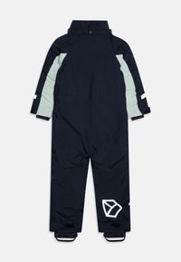 Jūros mėlynos spalvos vientisas snowsuit'as su šviesiai mėtos žalios spalvos akcentais, turintis aukštą apykaklę, atspindinčius elementus ir geometrinį logotipą ant kojos.