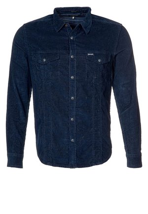 Tummansininen sekä samettinen pitkähiha-painonappipaita, jossa on kaksi rintataskua ja kaulus, esillä valkoista taustaa vasten.