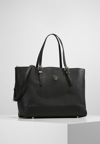 Černá taška na rameno vyrobená z texturovaného syntetického materiálu, se dvěma rukojeťmi, nastavitelým ramenním popruhem, zlatým kováním a logem na přední straně.