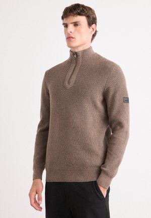 Pull-over en tricot marron avec un col zippé demi-long, doté d'un tissu texturé, d'une coupe slim et d'une patte logo sur la manche gauche.
