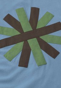 Tissu bleu avec des bandes de tissu rectangulaires marron et vert superposées, disposées en motif d'étoile.