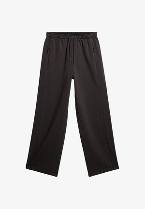 Pantalons noirs à jambes larges en tissu doux. Dotés d'une taille élastique avec cordon de serrage et de poches latérales. Texture lisse avec coutures droites.