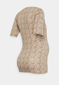 T-shirt de maternidade com mangas curtas, padrão floral rosa sobre fundo verde, tecido elástico, design ajustado, barra arredondada.