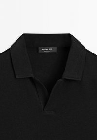 Polo noir à col avec une ouverture en V et une étiquette Massimo Dutti cousue à l'intérieur de la zone du col.