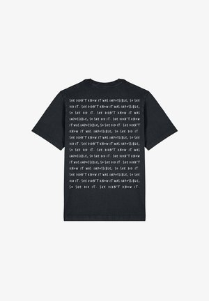 Zwarte katoenen T-shirt met korte mouwen. Witte tekst op de achterkant, met een herhalende zin over het overwinnen van onmogelijkheid. Ronde halslijn.