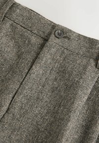 Gray wool trousers with a herringbone pattern, featuring a flat front, button closure, and a textured fabric finish.