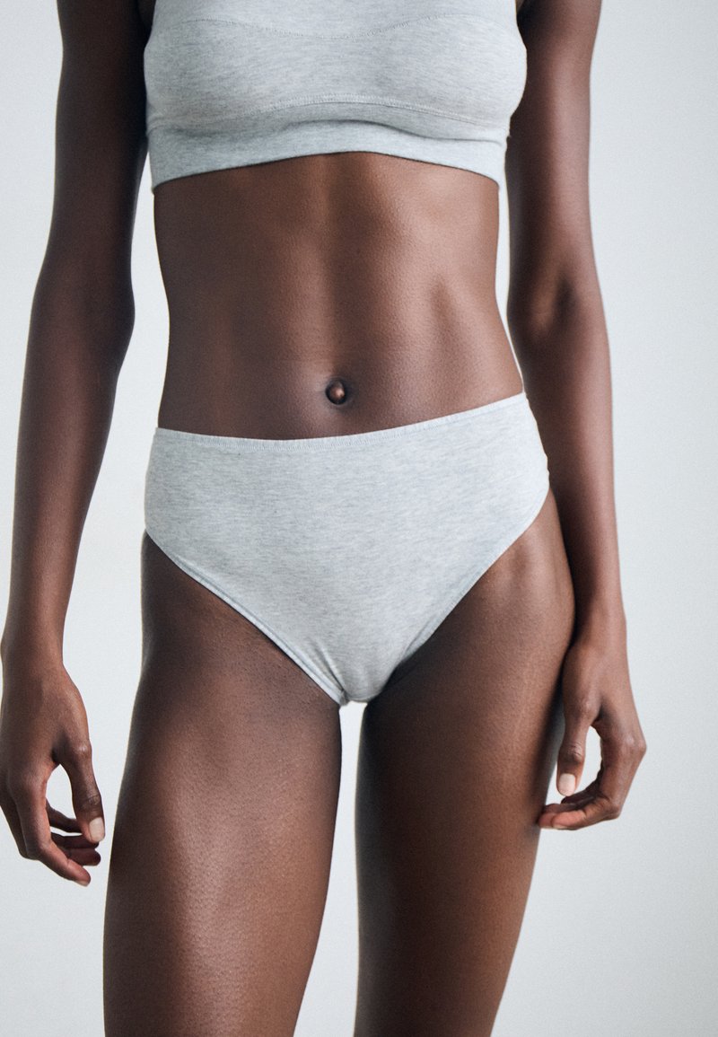 Set di bralette e culotte a vita alta in cotone grigio, con una texture liscia e un design semplice. Nessun motivo o dettaglio in metallo visibile.