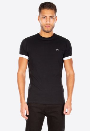 Schwarzes T-Shirt mit weißen, umgeschlagenen Ärmeln und einem kleinen Logo-Detail auf der Brust. Hergestellt aus weichem Stoff mit taillierter Passform.