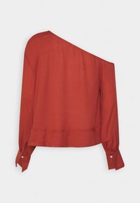 Blouse à manches longues couleur rouille avec un décolleté asymétrique laissant une épaule découverte et des poignets boutonnés, présentée sur un fond uni.