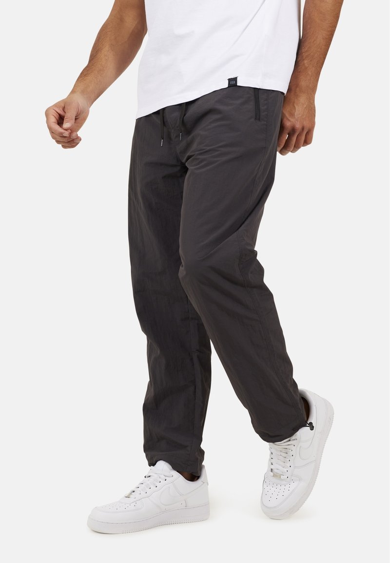 Ciemnoszare, lekkie spodnie z elastycznym pasem i regulowanym sznurkiem. Posiadają boczne kieszenie oraz dopasowany krój nogawek.