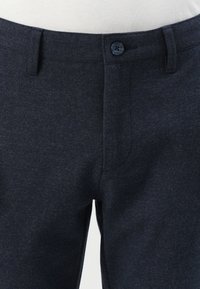 Pantalones azul oscuro de tela texturizada, con cierre de botón, bolsillos con abertura y un diseño de pierna recta.