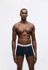 Μαύρα μποξεράκια με λευκή ελαστική μέση που φέρει την ένδειξη "BJÖRN BORG". Ο ύφασμα είναι λείος, με εφαρμοστό σχήμα.