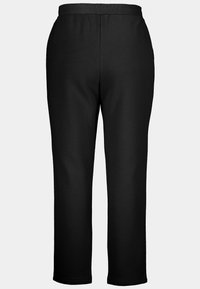 Zwarte sweatpants met een zachte, gladde textuur, met een elastische tailleband en rechte pijpen. Geen zichtbare zakken of versieringen.