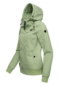Gaiši zaļa jaka ar kapuci, priekšējo rāvējslēdzēju un sānu kabatām. Iespējas elastīgas piedurknes un auklas regulēšana, lai nodrošinātu drošu piegulšanu.