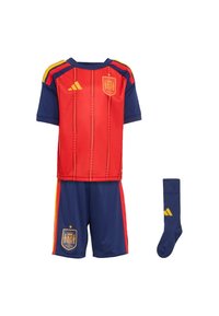 Futbalový dres v červenej a tmavomodrej farbe s vertikálnymi pruhmi, erbom Španielska a značkou Adidas; obsahuje dres, šortky a tmavomodré ponožky.