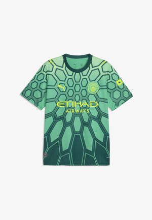Maillot de football vert de Manchester City avec motif hexagonal, logos jaunes Puma et Etihad Airways, et écusson du club sur la poitrine.