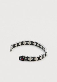 Srebrno-czarna metalowa bransoletka z przeplatającymi się ogniwami, gładkim wykończeniem oraz prostokątną klamrą z logiem.