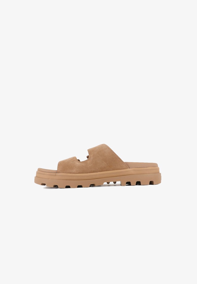 Sandale mule en daim beige avec une semelle épaisse en caoutchouc à relief et deux découpes sur la bride supérieure, vue de côté sur fond blanc.