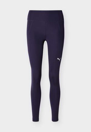 Tumedat lilla täispikkuses jõusaalipüksid kõrge vöökohaga ja väike valge Puma logo parema reie peal.