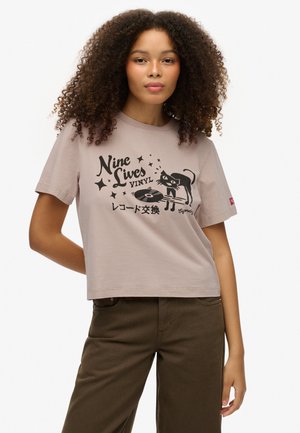 Jasnoróżowy bawełniany t-shirt z krótkimi rękawami z czarną grafiką kota i winylowej płyty, dopełniony tekstem i gwiazdkami.