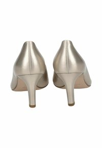 Chaussures à talons hauts beiges avec une finition en cuir brillant, bout pointu et un talon fin. Le design présente des coutures minimales et aucun embellissement.