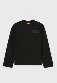 Sweat-shirt noir à manches longues avec col rond, logo discret "032c" sur le côté gauche de la poitrine et étiquette intérieure rouge au niveau du col.
