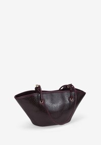 Bolso de tote de cuero en burdeos profundo, con una superficie texturizada, forma triangular única, dos asas anudadas y acentos de hardware en tono dorado.