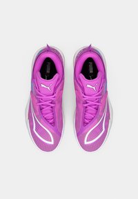 Violetas sporta kurpes ar teksturētu acs virsu, baltu dizaina akcentu, izšūtu apkakli un apaļiem šņorēm. Redzama gumijas zolīte.