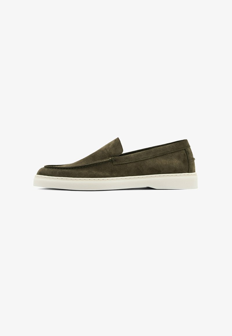 Scarpa slip-on in suede verde oliva con punta arrotondata, suola in gomma bianca e dettagli di cucitura minimi lungo la parte superiore.