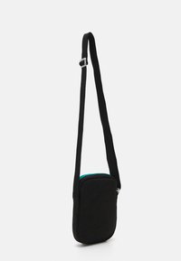 Fekete, téglalap alakú, szövetből készült válltáska, türkiz cipzárral és állítható pánttal. Sima textúra, minimális díszítéssel.
