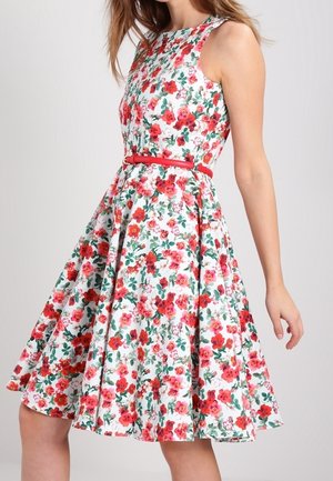 Ærmeløs hvid kjole med rødt og pink blomstermønster, tilspidset talje med tyndt rødt bælte og udvidet skørt, der ender over knæet.