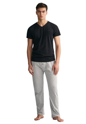 Sort bomulds V-hals T-shirt parret med lysegrå bomulds pyjamasbukser med knaplukning foran. Glat tekstur, afslappet pasform.