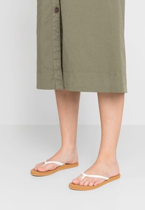 Braune flache Sandalen mit einem weißen geflochtenen Riemen, ausgestattet mit einer strukturierten Gummisohle und einem minimalistischen Design, ideal für den Alltag.