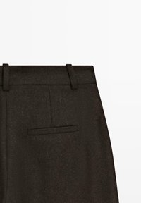 Pantalons en laine noirs avec un devant plat, des passants de ceinture et une poche arrière unique avec une finition texturée subtile.