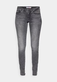 Jeans skinny de mezclilla gris oscuro con un acabado ligeramente desgastado, que presentan detalles en desgaste, cinco bolsillos y una cintura con logo.