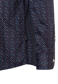 Camicetta blu navy con un motivo geometrico a diamante rosso e bianco. Maniche corte, polsini con bottoni e un'etichetta laterale sul bordo.