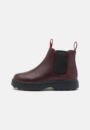 Burgundy leather Chelsea boot with black elastic side panels, pull tabs, rounded toe, and a textured black rubber sole.