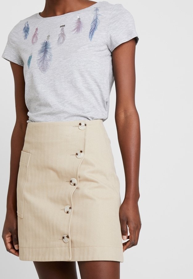 Camiseta gris con diseños de plumas en azul y rosa; falda beige con rayas verticales, bolsillo lateral y seis botones de cierre.