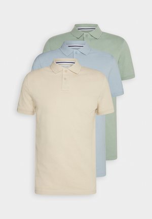 Tres camisetas polo de manga corta en beige, azul claro y verde claro; material de algodón, cuello clásico, dos botones, textura suave.