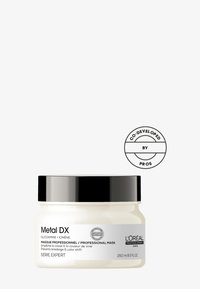 Hvit krukke med svart lokk, merket "Metal DX" i svart tekst, inneholder 250 ml. Har et sirkulært "Co-developed by Pros"-logo.