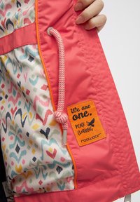 Heldere roze jas met een geblokte voering met multicolore ontwerpen. Inclusief een geweven trekkoord en een label met tekst en logo.