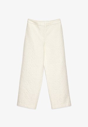 Pantalons larges blancs en tissu texturé avec un motif en relief, dotés d'une taille lisse et sans poches visibles.